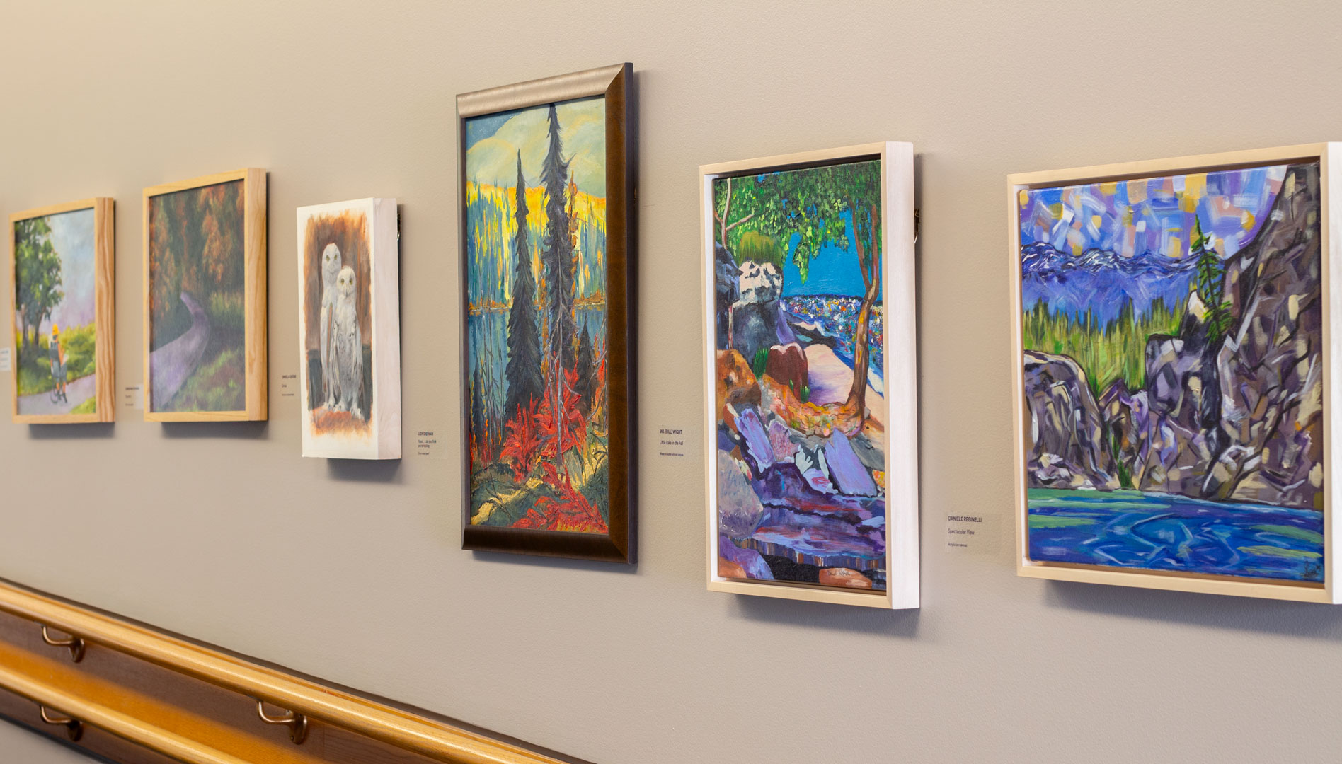 Image from inside the gallery, wall with row of paintings