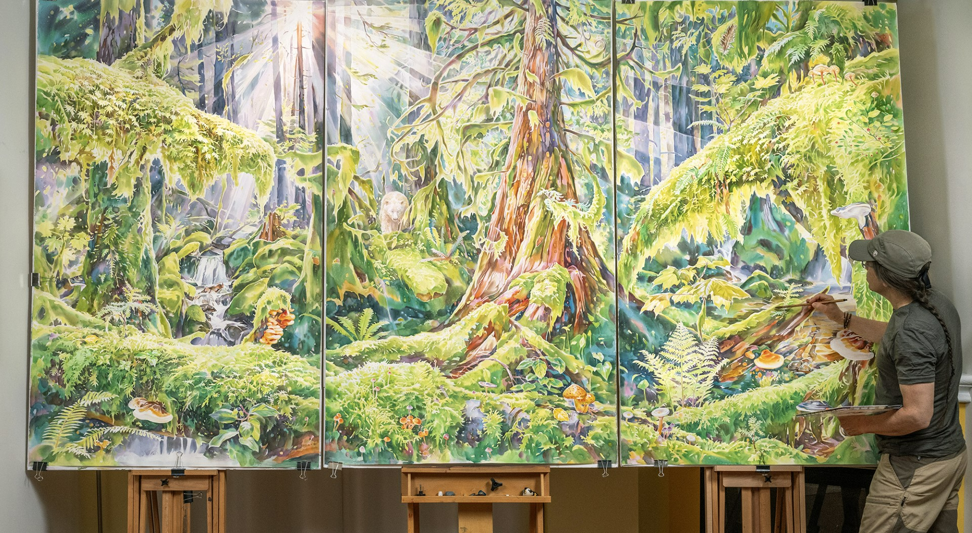 artist painting a forest on a mural