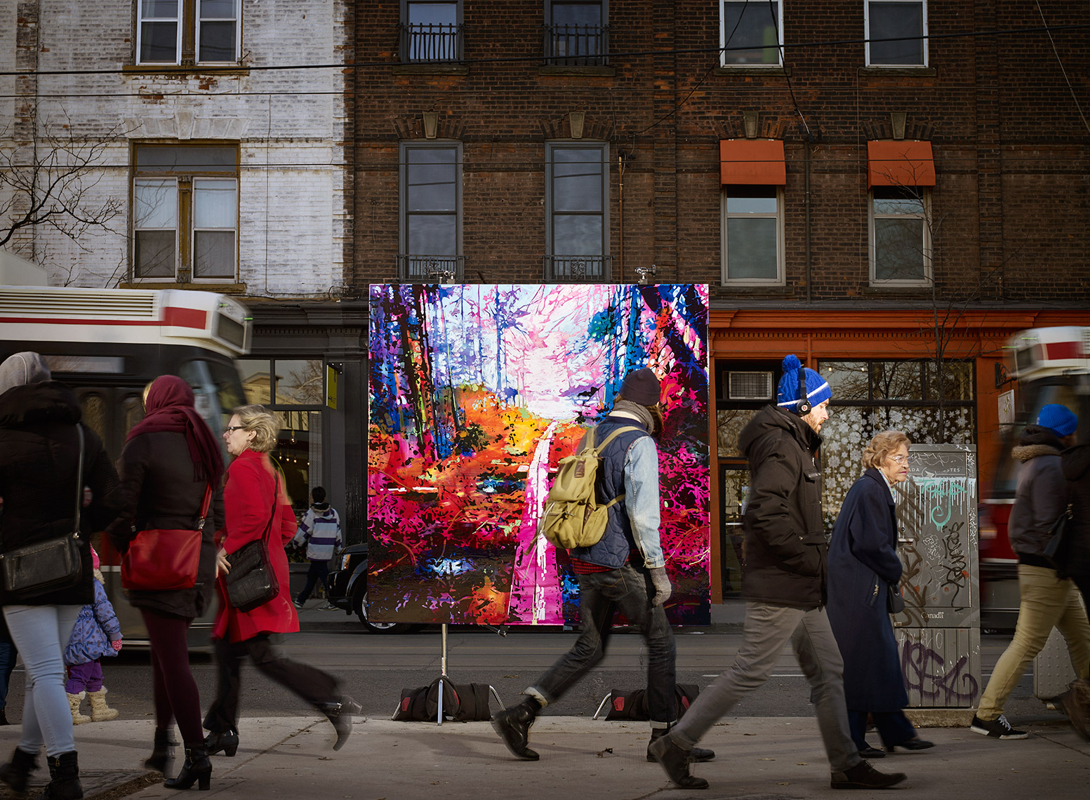 photograph of a landscape painting on a stand in a city street. People walking by on sidewalk and a streetcar
