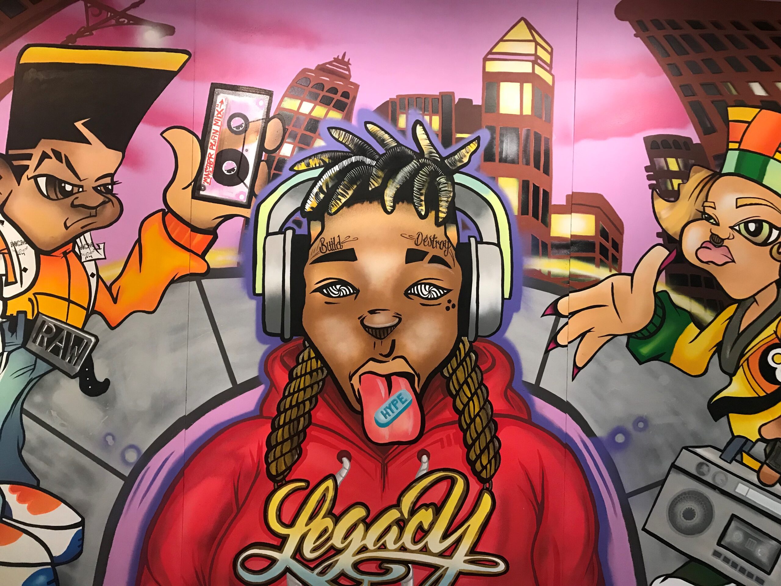 graffiti-style painting of three people with buildings behind them